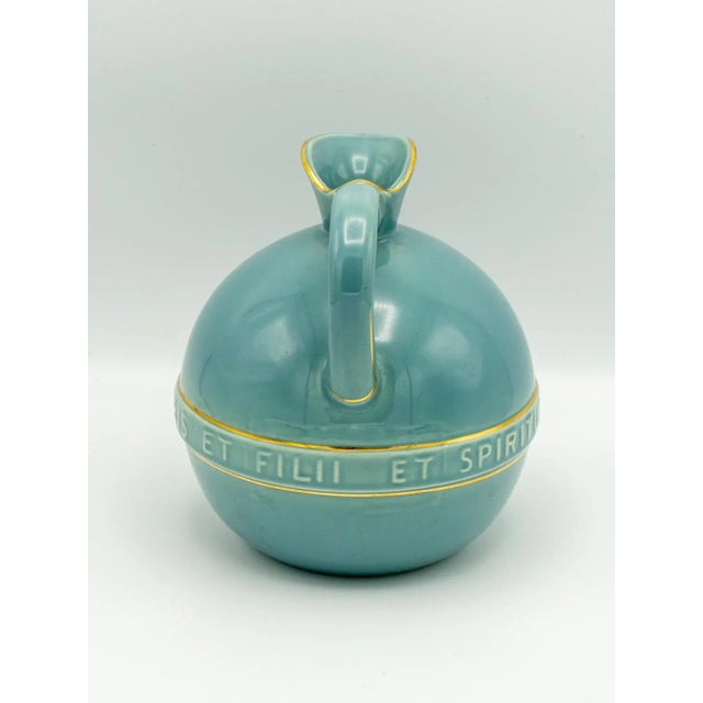 This rare ceramic communion wine jug, crafted in the 1950s by Plateelbakkerij Zuid-Holland Gouda pottery, reflects the...