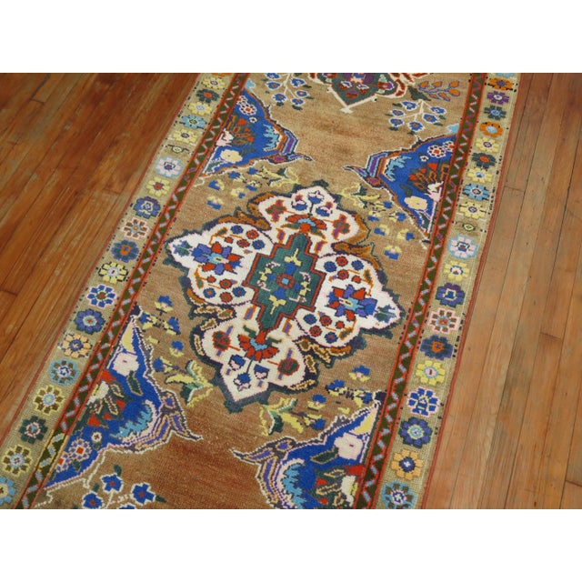 A colorful Turkish Anatolian runner from the middle of the 20th century. A formal palette with intense colors on a camel...
