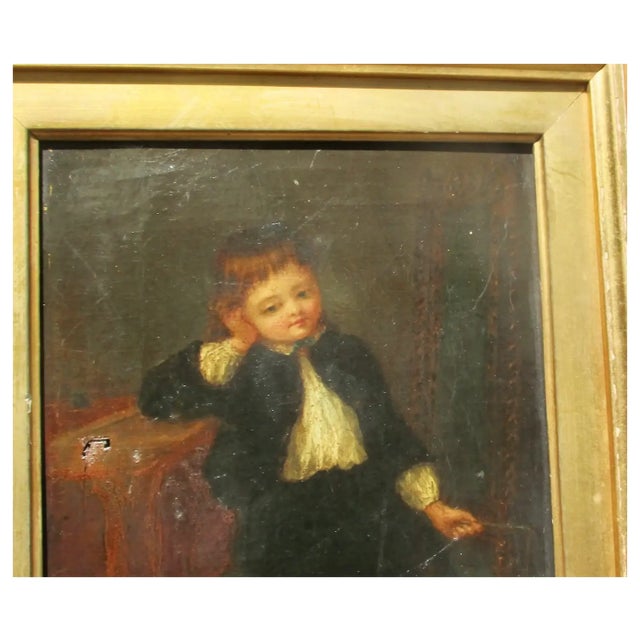 A friendly portrait of a child with toys in fine dress. Full and proper dress, black coat and white lacy shirt, the table...