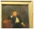 A friendly portrait of a child with toys in fine dress. Full and proper dress, black coat and white lacy shirt, the table...