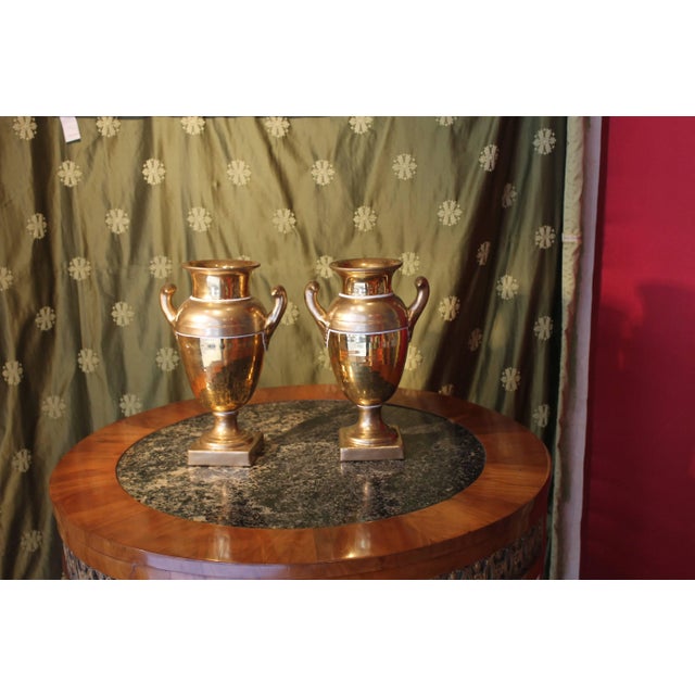 Pair of French 19th century Empire porcelain two handles baluster-shaped vases. The body of each vase is in two-toned gold...