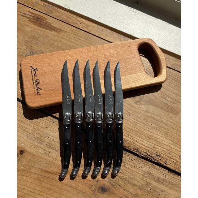 Set of six classic French Laguiole steak knives featuring sleek black handles with stainless steel rivets and polished...