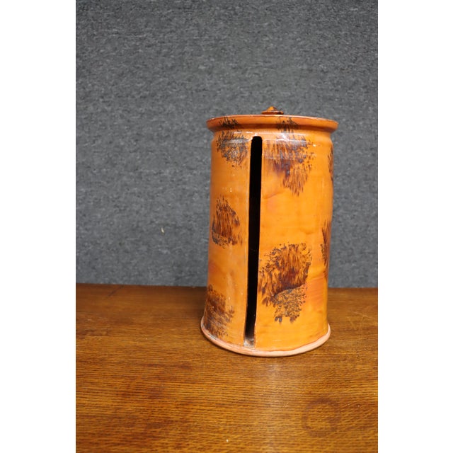 Handcrafted stoneware paper towel holder by David T. Smith, featuring a cylindrical form with a fitted lid, warm burnt-...