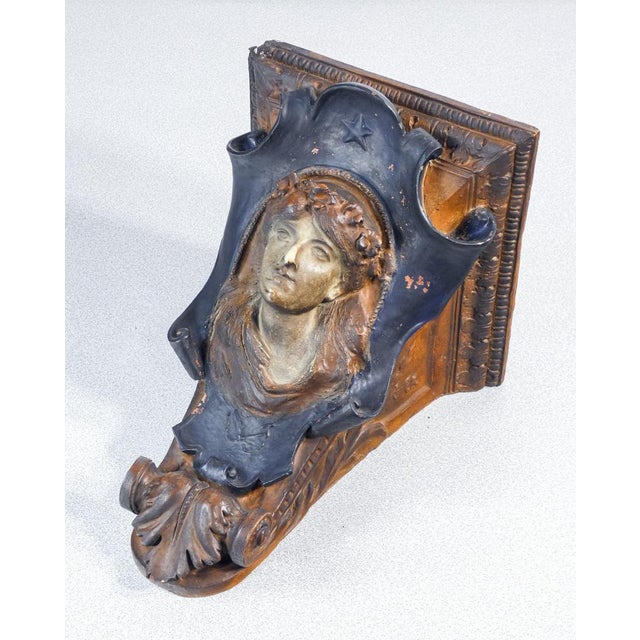 Sculpted and painted terracotta shelf with a woman's face and neoclassical-style decorations. 19th century period 19th...