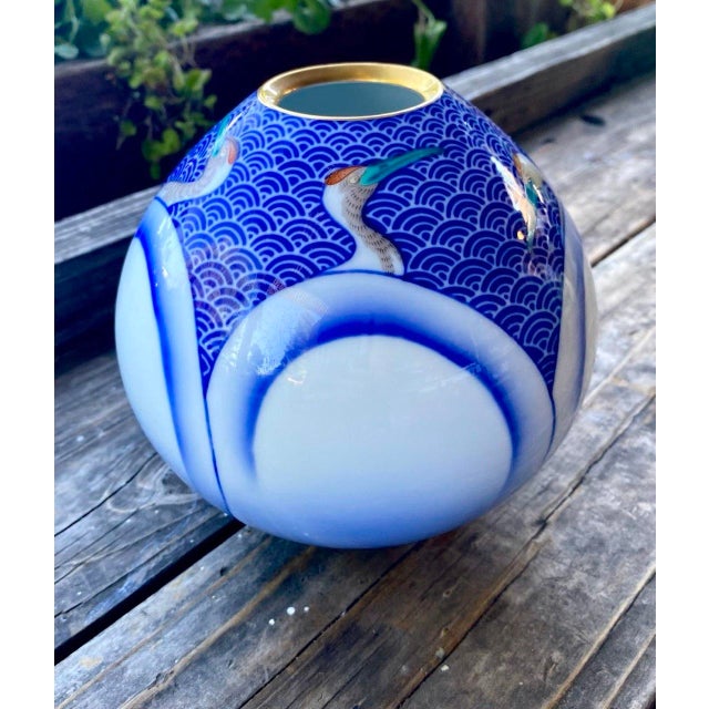 Exceptional vintage Japanese porcelain vase featuring a sculptural spherical form decorated with graceful cranes floating...