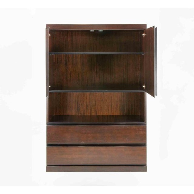 Realized in rosewood and metal, this elegant storage unit, despite its age, is in near perfect condition. It was realized...