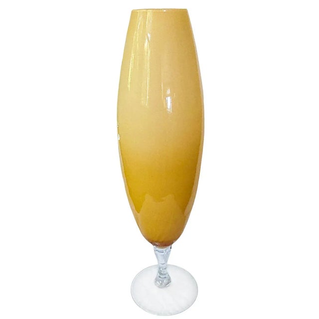 The Gigantic Flute Sleek Vase form and shape offered in champagne color, serves as a modern vase featuring an elevated...