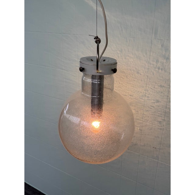 Suspended chandelier with a spherical shade made of Pulese glass. Made in Murano. Made in Italy in the 1960s. The shade’s...