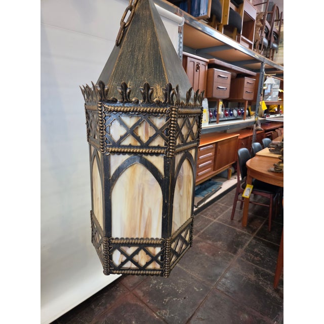 This Tudor Church Gothic Chandelier Fixture is a metal with patina finish. There is one light and 24 inches of chain. The...