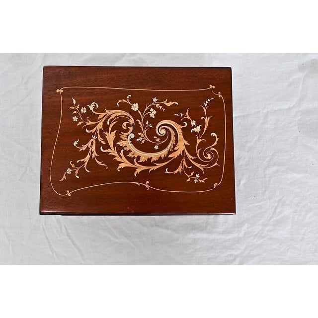 A darling, Georgian-style jewelry box from 19th century England made of rosewood meticulously inlaid with scrolling...