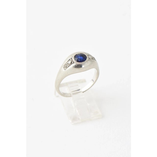 Art Deco platinum ring featuring an oval sapphire mounted with two diamonds on each side. US size 7.25; can be sized. Acid...