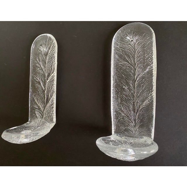 A wonderful pair of mid century cast glass sconces attributed to Kosta Boda. Each sconce features a pine needle-like motif...