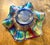 This Fenton piece is a classic example of antique Carnival glass with an iridescent “oil finish”. It has a multi-colored...