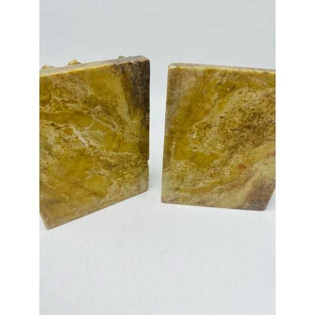 This is a matched pair of carved stone bookends, notable for their weight, symmetry, and finely worked relief. Each...