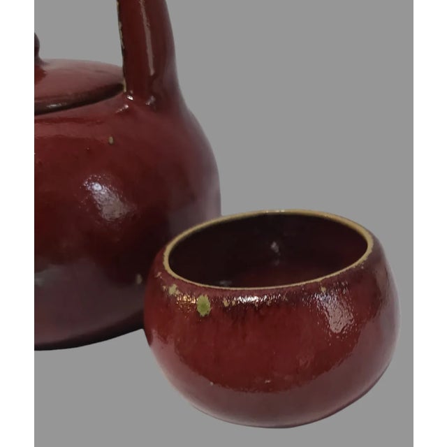 This vintage Asian teapot and two cups set is a must-have for any tea enthusiast. The bright red glaze and intricate...
