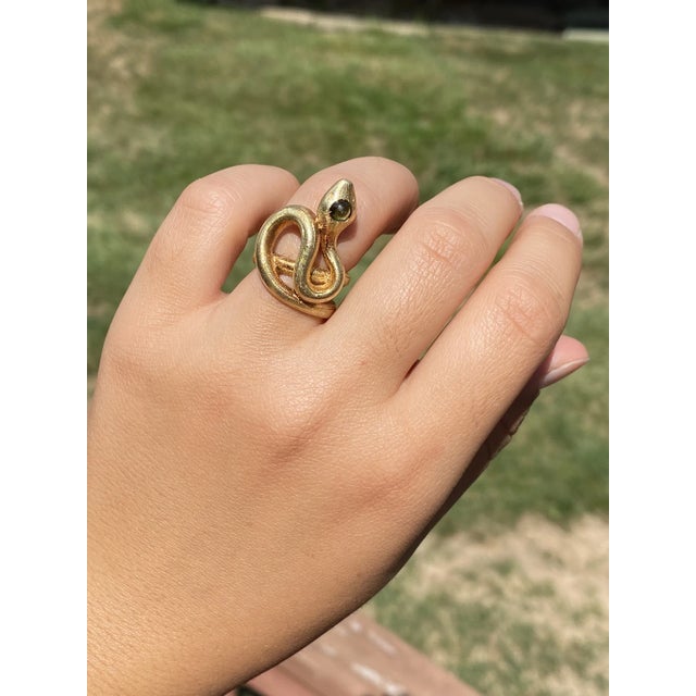 The Hibbs: Ladies 18K Yellow Gold Snake Ring set with Peridot. Artfully crafted in 18 karat yellow gold, this bold...