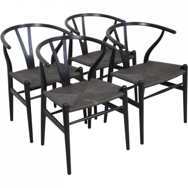 Hans Wegner CH24 wishbone chairs with frames of black lacquered oak and seats of black wicker. The chairs are from the...