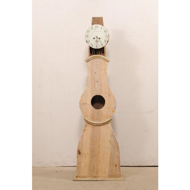 A wood-carved Swedish Mora floor clock from the 19th century. This antique Mora clock from Sweden features a raised and...