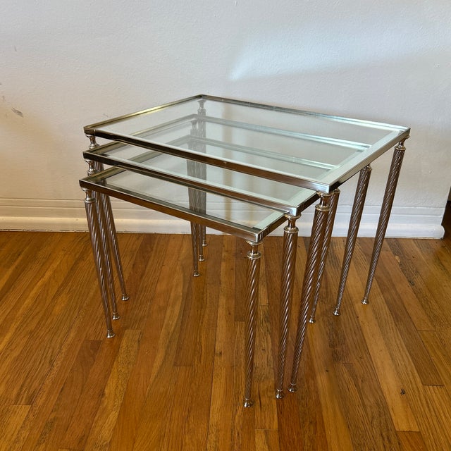 Stunning set of 3 Maison Jansen graduating nesting tables in nickel finished brass. The tables have elegant squared frames...