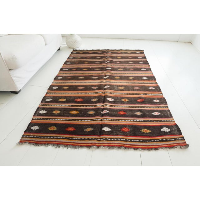 This is a vintage Turkish Oushak rug from the Mid 20th Century. The piece was hand-knotted.