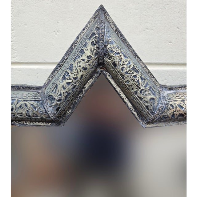 A vintage handmade Moroccan mirror featuring a striking star‑shaped metal frame with traditional engraved motifs blending...