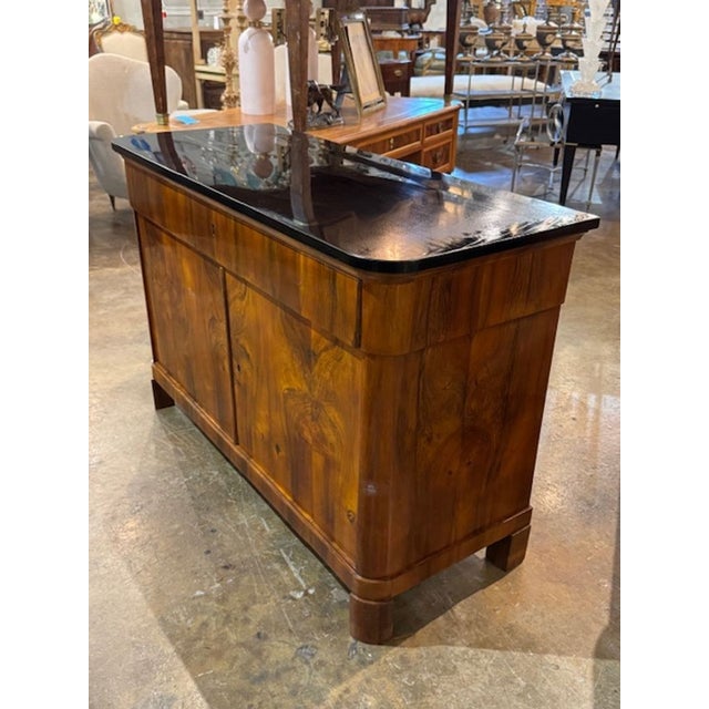 This 19th century German walnut and black lacquered Biedermeier commode is a classic piece of antique furniture. Its...