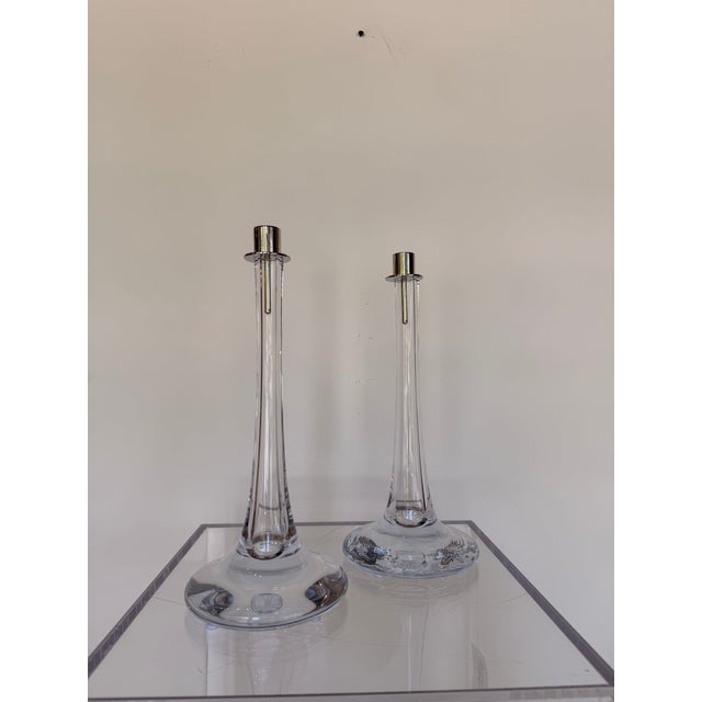 Contemporary candle holder featuring a sculptural clear crystal body topped with a polished nickel candle cup. The sleek...