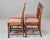 A set of four late Victorian oak side chairs, circa 1890, carrying the ornate confidence of the Gothic Revival style. The...
