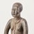 This intricately carved wooden figure represents a female of the Mossi people, seated with her hands resting on her knees....