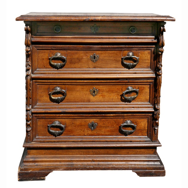Rectangular top over four drawers flanked by carved decoration, raised on bracket feet.