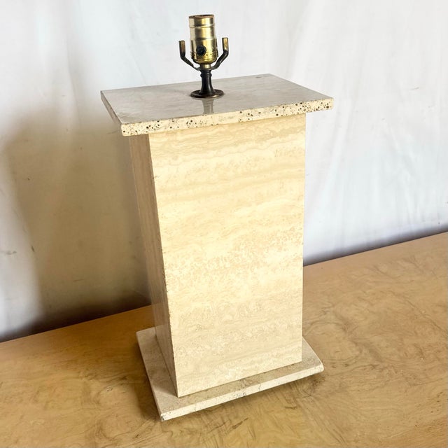 This sculptural travertine table lamp showcases a clean, modern silhouette crafted from beautifully veined natural stone....
