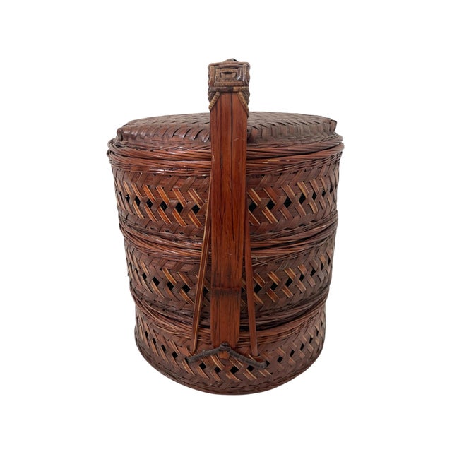 This vintage Chinese rattan tiered nested compartment box is a hand-woven piece with a dark wood tone, originating from...