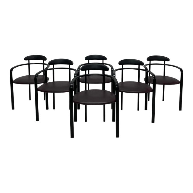 Postmodern dining chairs by Hank Loewenstein circa 1980s. The black enamel steel frame supports a purple vinyl cushioned...