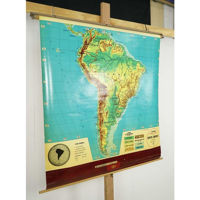 The vintage Cram's Physical Political roll up school map of South America, crafted from pine wood, steel, and canvas, is a...