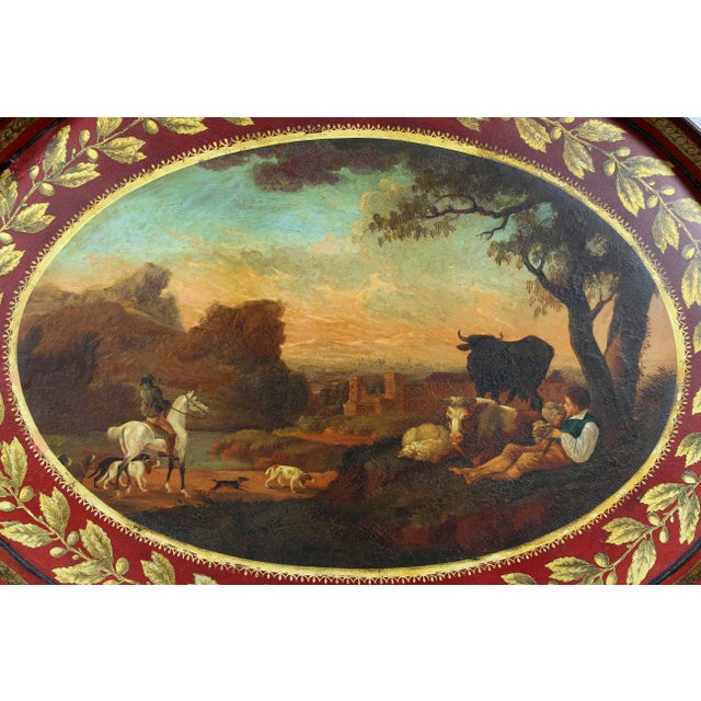 Oval with red ground and gilt leaf tip outer border, beautifully painted central pastural scene.