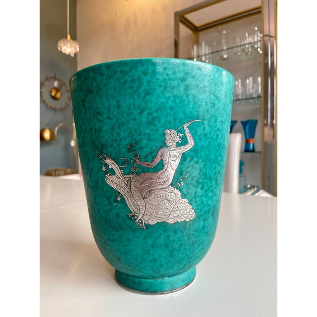 A particularly beautiful ceramic vase with iron glaze and silver mount in the shape of an Aquarius. This piece has an...