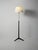 1950s/1960s floor lamp in black lacquered wood and brass, with a trilobed base. Lampshade remade in the style of the...