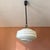 Elegant Mid-Century Modern hanging pendant lamp featuring a beautifully reverse-painted white glass shade with a soft...