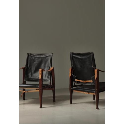 Beautiful pair of vintage "Safari" chairs in deeply patinated black leather and dark stained solid ash. Designed by Kaare...