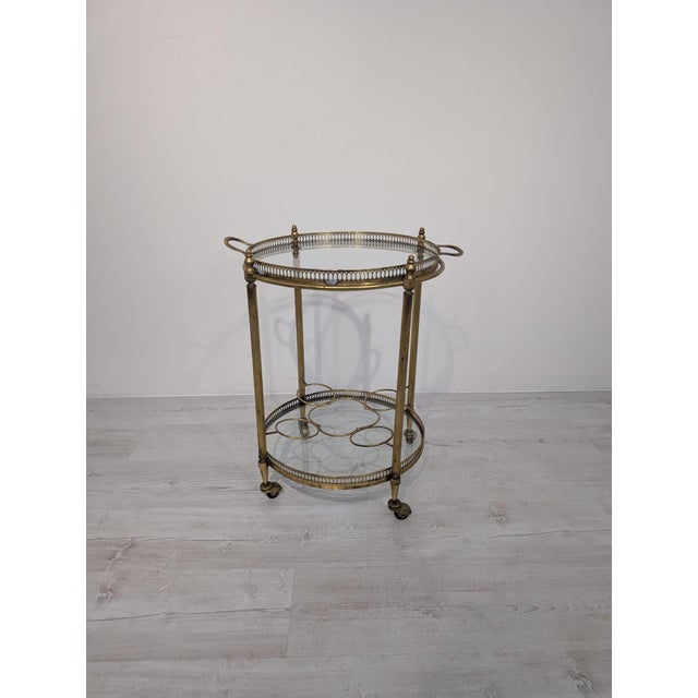 French Mobile Brass Bar from the 1950s This mobile brass bar table from the 1950s features two glass shelves on wheels for...