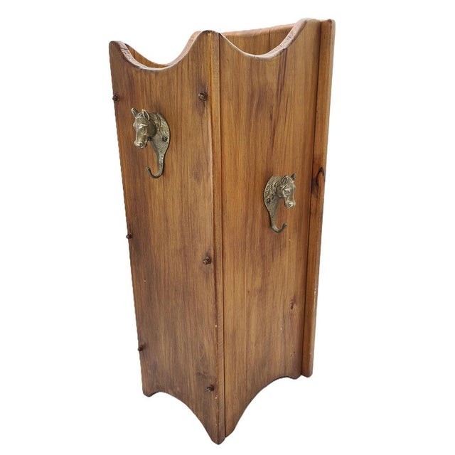 An original wooden stand in a rustic/hunting style with decorative brass handles shaped like horse heads. A very...