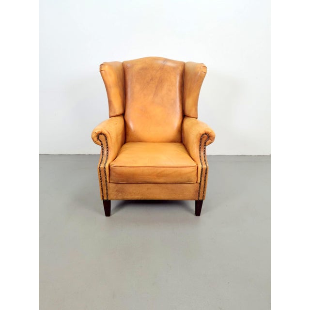 Vintage sheepskin leather wing-back armchair This beautiful sheepskin leather wing-back armchair features a timeless...