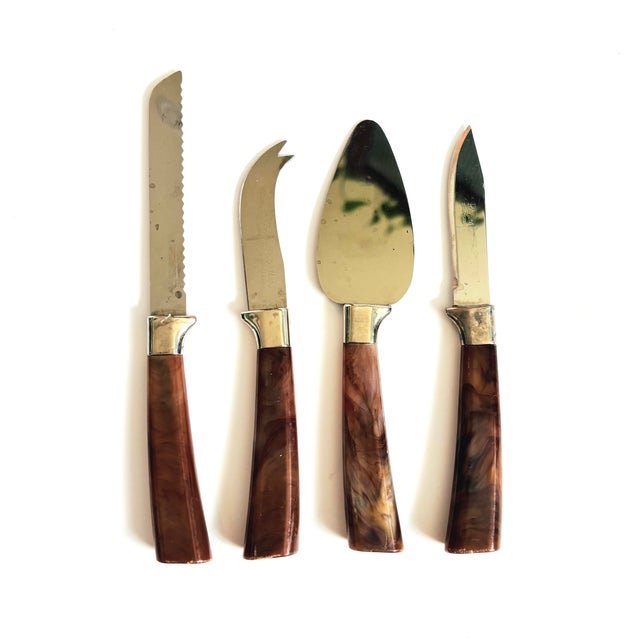 A set of 4 vintage stainless steel cheese serving tools by Sheffield, England. Each features a tortoiseshell plastic...