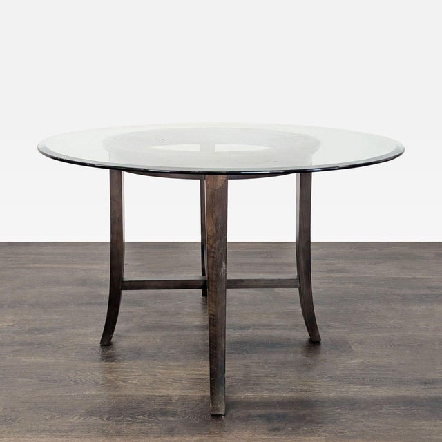 This dining set includes a round glass-top table with a sturdy wooden base and four comfortable chairs. The chairs feature...