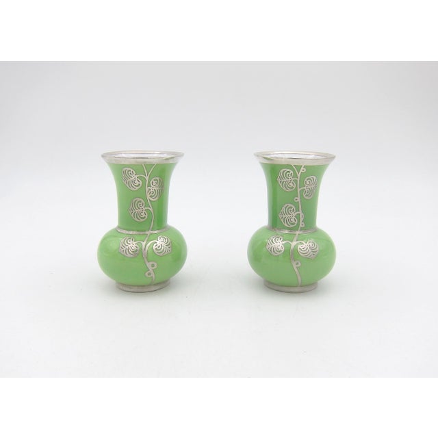 A diminutive silver overlay porcelain vase pair from Manfred Veyhl of Germany, dating circa late-1940s to the early-1950s....