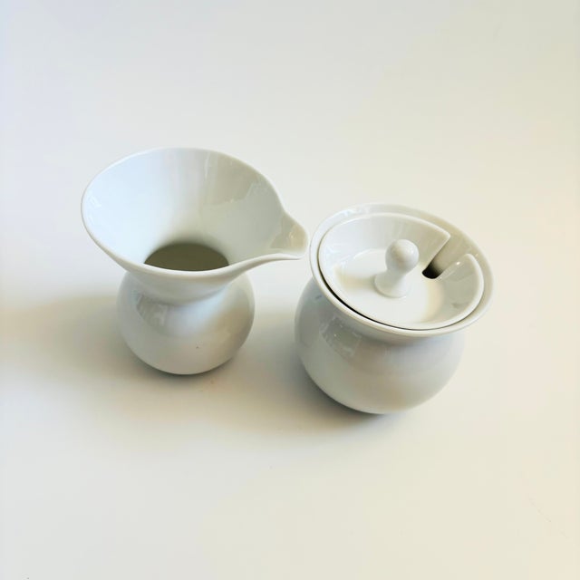 A mid century porcelain creamer and sugar bowl set designed by LaGardo Tackett. Simple modernist design with round bottoms...