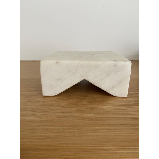 A beautifully carved white marble three‑loop chain displayed with a coordinating solid marble square pedestal. The set...