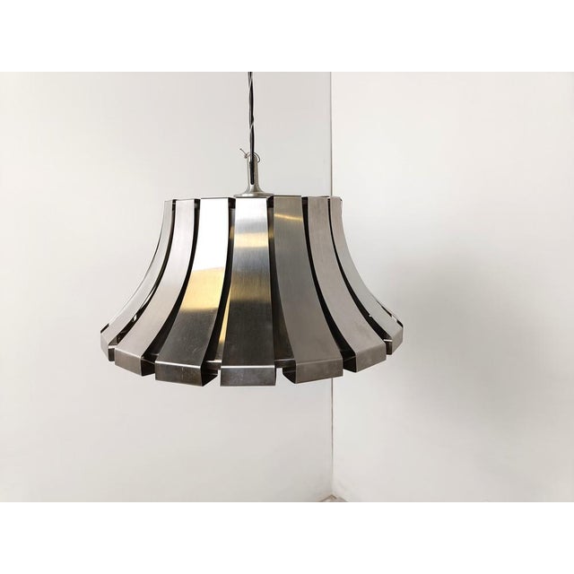 Italian suspension light by Elio Martinelli for Martinelli Luce. Beautiful timeless design made from steel bands all...
