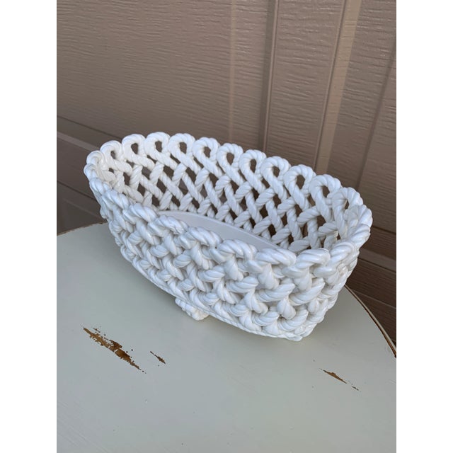 An elegant trompe l'oeil porcelain cachepot crafted in the form of a handwoven rope basket. Executed in glossy white...
