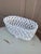 An elegant trompe l'oeil porcelain cachepot crafted in the form of a handwoven rope basket. Executed in glossy white...